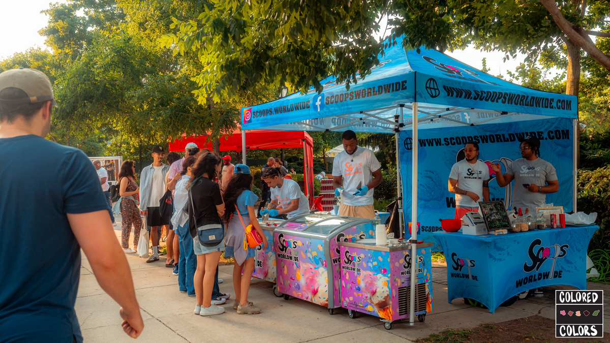 Guests gathered around the blue Scoops Worldwide tent